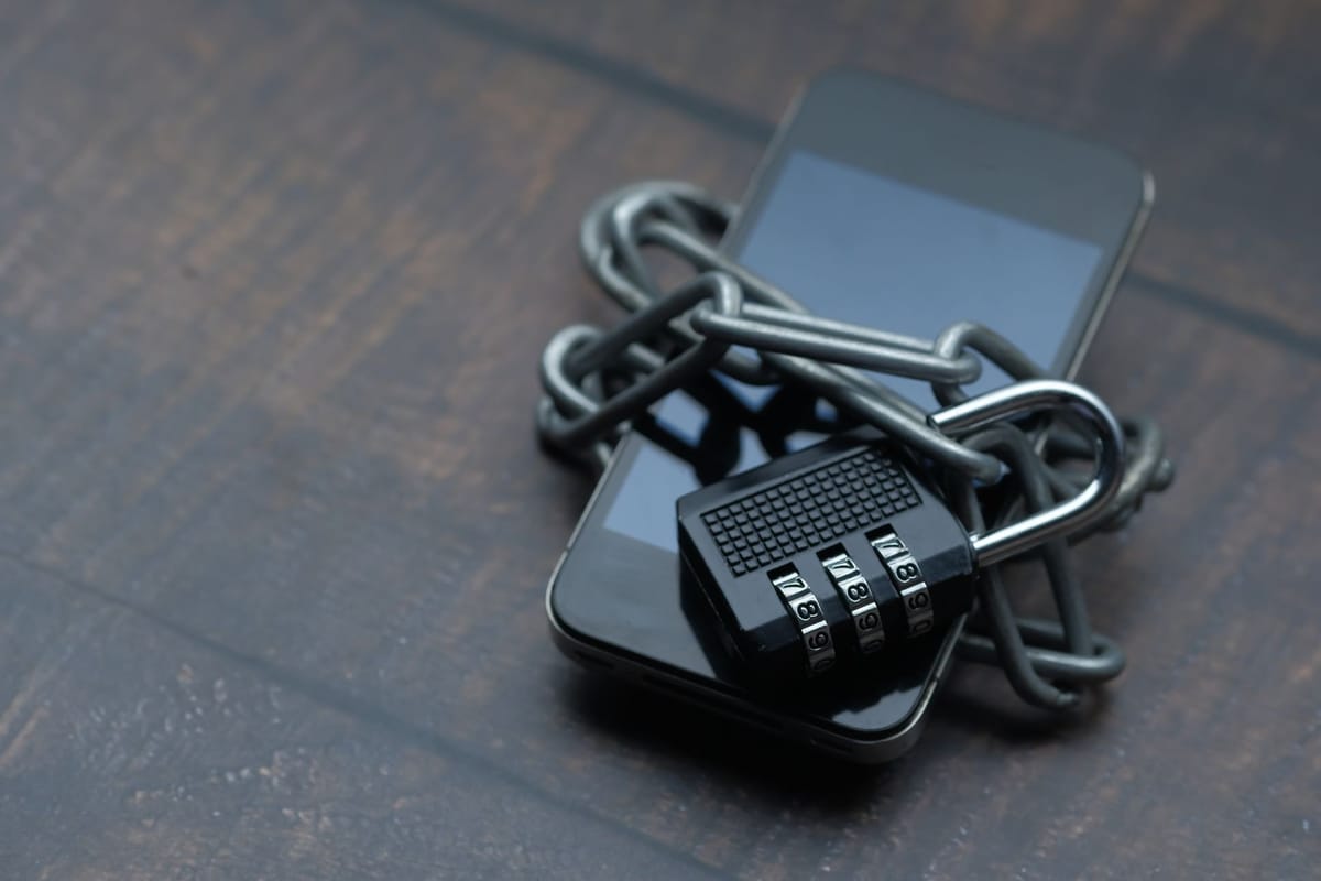 A smartphone wrapped in a chain and locked with a padlock
